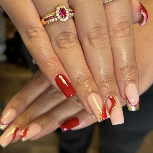 Long BIAB nails finished with elegant red nail art, created at Sirens Beauty Salon in Durham.